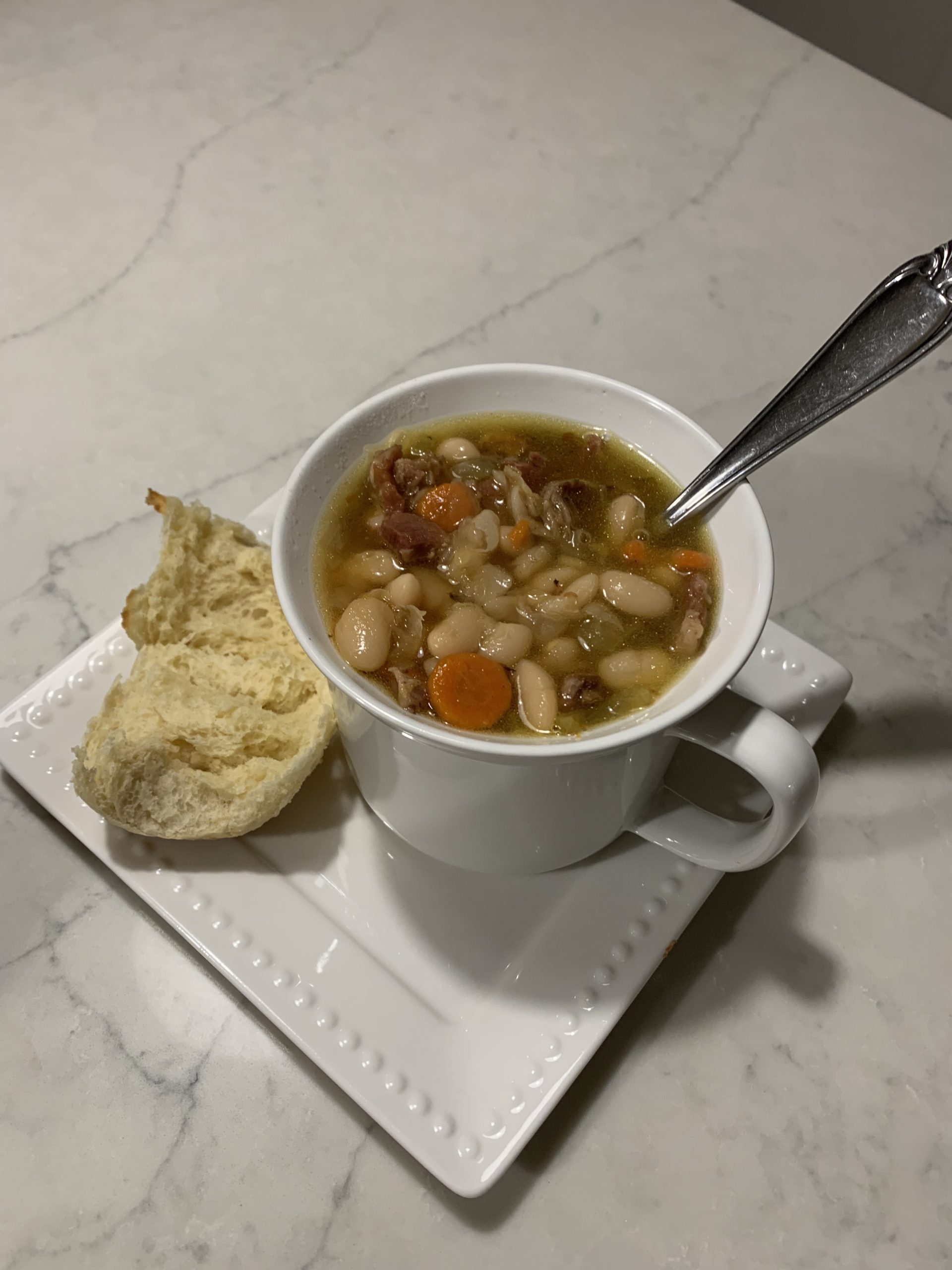 Finished ham and bean soup with a dinner roll