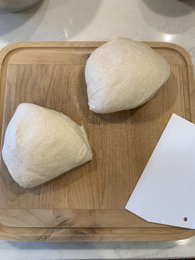 Dough divided into two loaves with bench knife