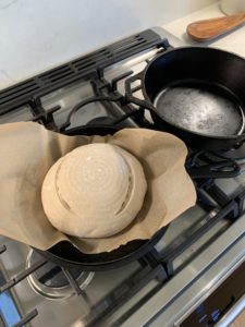 Placing the loaves in the ovens with the parchment paper